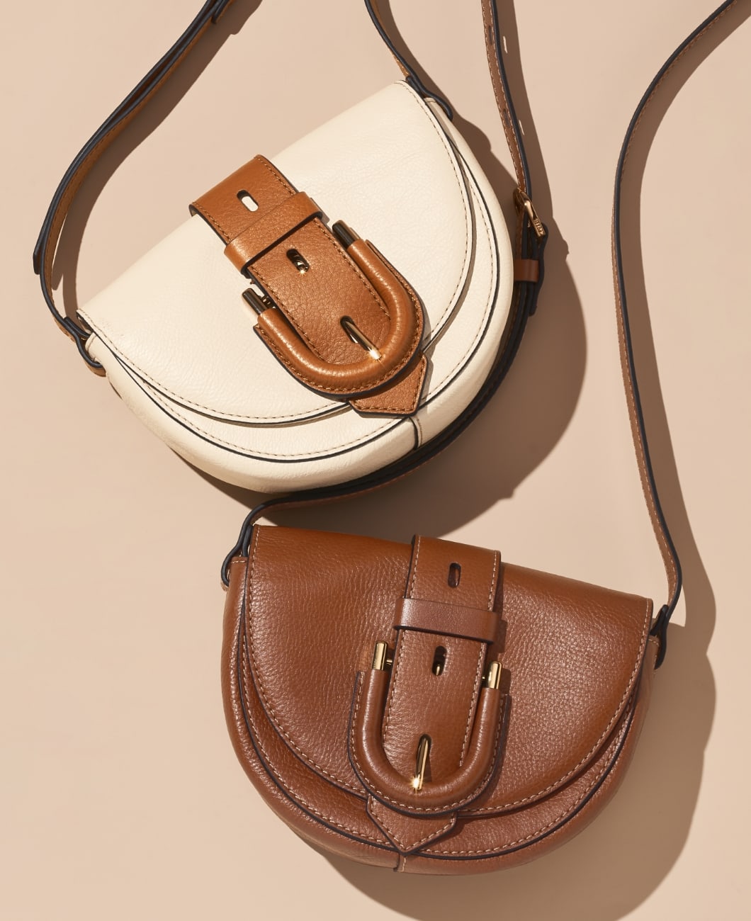 A woman lounges on a soft brown couch with her Liza camera bag in hand. It features an adjustable strap and a woven leather pattern in bright, punchy colors.