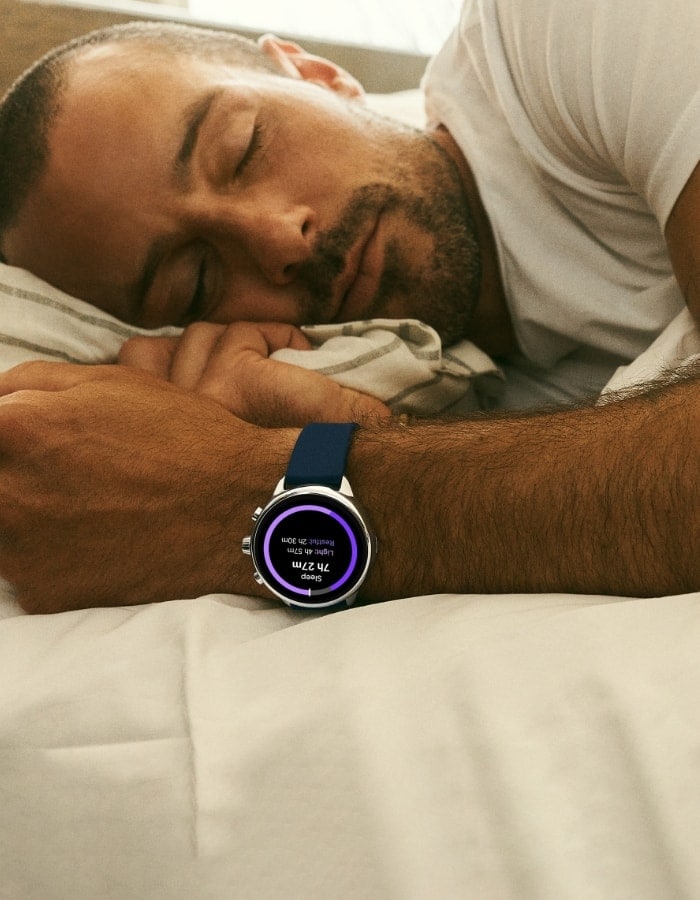 Un homme endormi qui porte une montre connectée hybride Gen 6 édition Wellness.