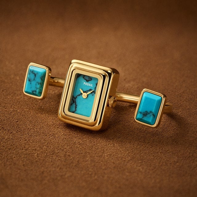 A rectangular Raquel Watch Ring with a gold-tone sunray watch face and a flexible band to fit any finger.