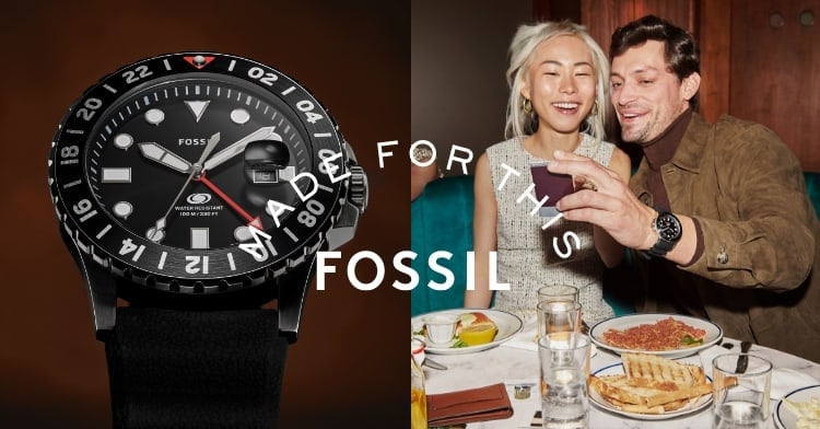 Made For This Fossil. A woman and a man smiling and looking at a photo. He is wearing the Fossil Blue GMT.