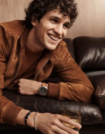 A man smiling wearing a Fossil Heritage watch. 