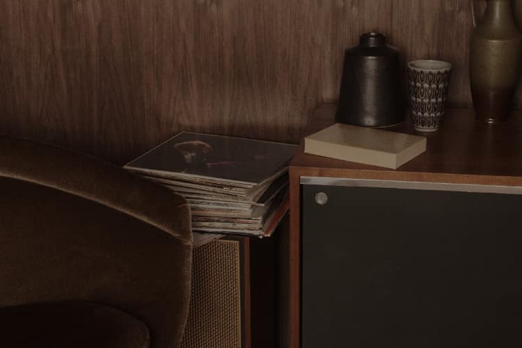 A record player in a panelled living room with a bow graphic.