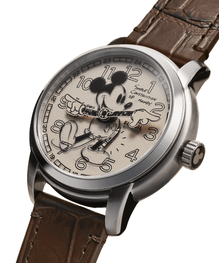 La montre Sketch Disney Mickey Mouse est présentée avec une illustration de Mickey Mouse de Disney, une photographie de Walt Disney en noir et blanc dessinant dans son studio d’animation et des détails de la couronne de la montre affichant la silhouette de Mickey. Les mots « Archival Mickey sketch » sont écrits sur la page.