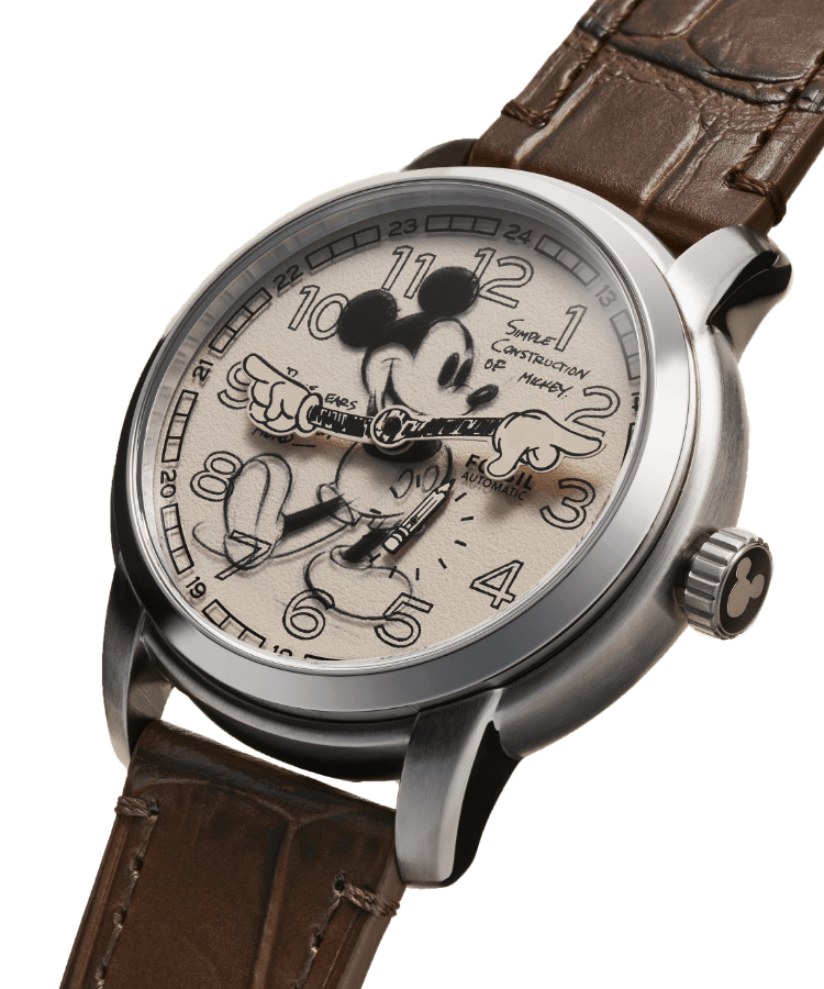 Man sieht die Uhr Sketch Disney Mickey Mouse mit einer Illustration von Disneys Micky Maus, einem Schwarz-Weiß-Foto von Walt Disney beim Zeichnen und ein Detailbild der Uhrenkrone mit Mickys Silhouette. Daneben sind die Worte „Archival Mickey Sketch“ in Schreibschrift.