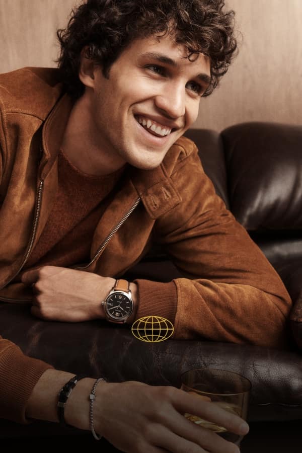 Eine Weltgrafik. Lächelnder Mann mit einer Uhr Fossil Heritage.