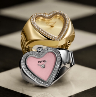 The gold-tone heart-shaped watch ring stacked on top of the silver-tone heart-shaped watch ring.