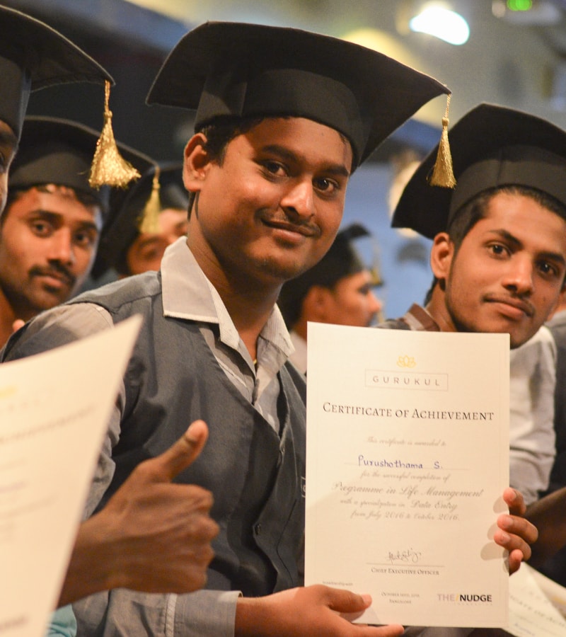 Young adults wearing mortar boards and holding certificates of achievement