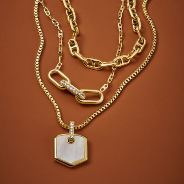 Three gold-tone Fossil Heritage jewelry necklaces.