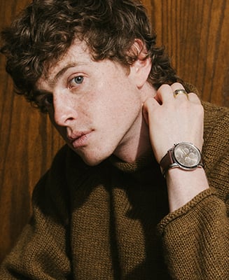 A man wearing a casual brown jacket and the Neutra watch.