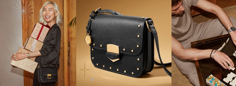 A woman smiling and carrying a stack of gifts in a red bow. The black leather Lennox handbag with stud accents. A man playing dominoes and wearing a Fossil Blue GMT watch.