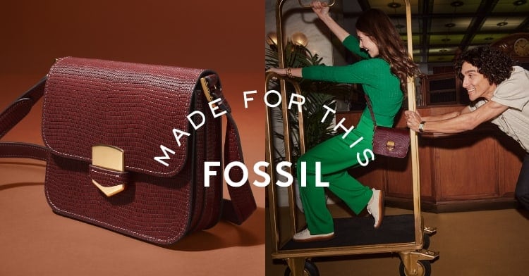 Made For This Fossil. A woman in a green jumpsuit wearing a brown Lennox bag and being pushed in a hotel trolley cart by a man wearing a Carraway watch.