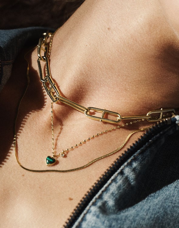 Zoom on woman's neck wearing the Heritage D-Link chain and the Modern Meadows Reconstituted Green Malachite Heart Pendant Necklace