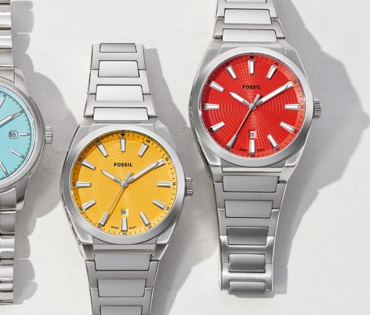 An autocarousel of five silver-tone watches with colored dials, including green, lavender, light blue, bright yellow and red.