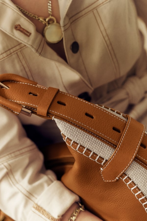 A woman holding the brown leather and cotton Harwell bag.