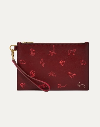 Un portafoglio rosso con cinturino da polso e animali stampati sopra.
