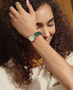 Ein Lifestyle-Bild einer Frau, die eine Uhr Harlow mit grünem Lederband trägt.