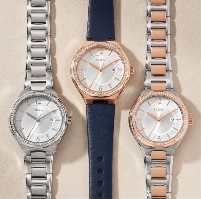 Three styles of our women’s Eevie Mini watch: silver-tone bracelet, navy blue leather strap with a gold-tone case and a mixed-metal gold-and-silver tone bracelet watch. All three styles feature a sparkling topring.