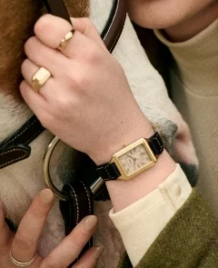 A lifestyle image of a woman wearing the Raquel watch stacked with a bracelet.
