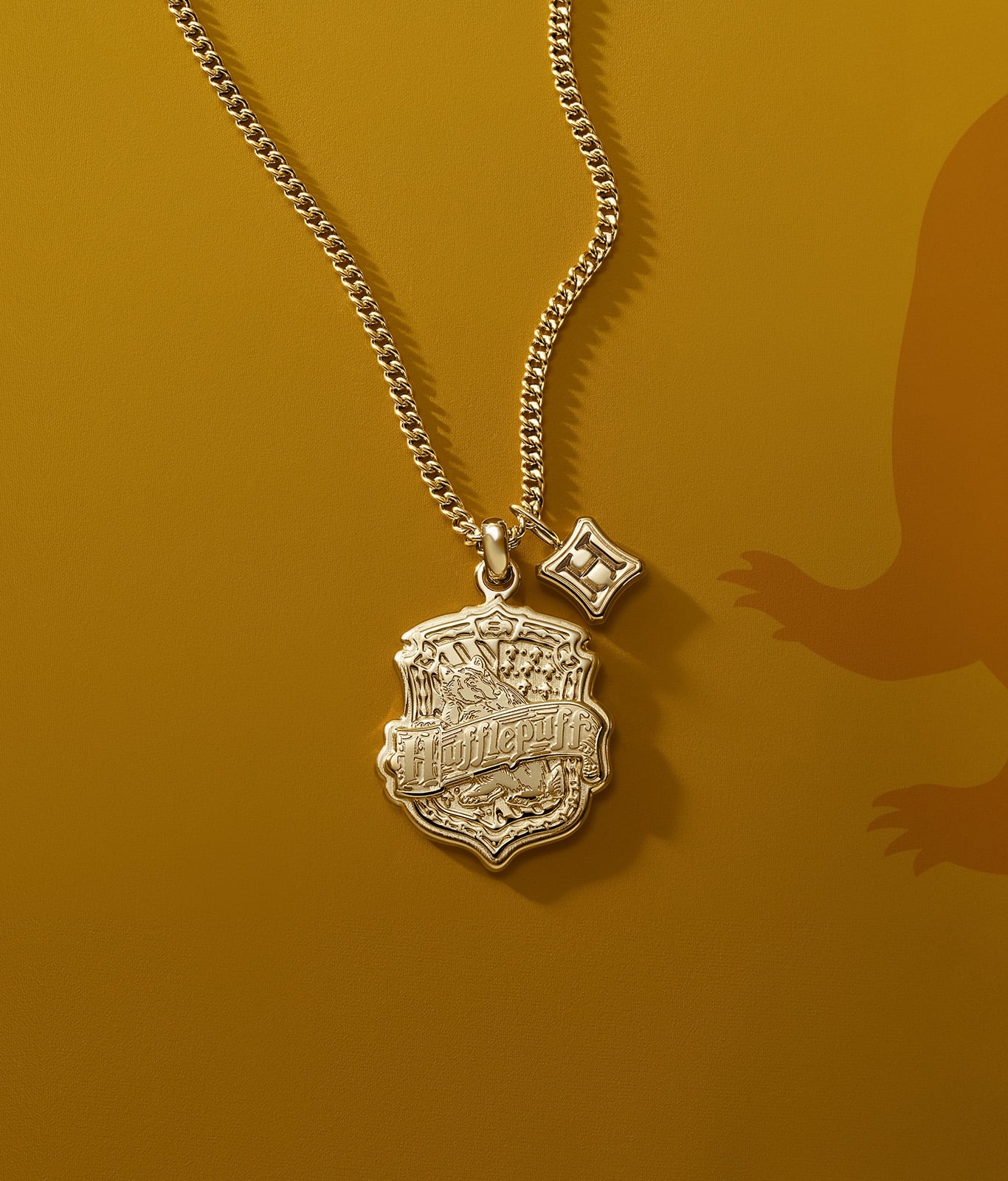 A gold-tone Hufflepuff house pendant.