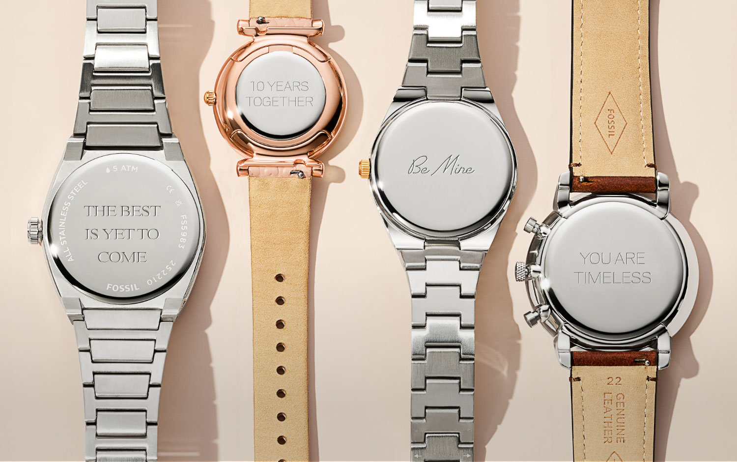 The backs of four engraved Fossil watches.