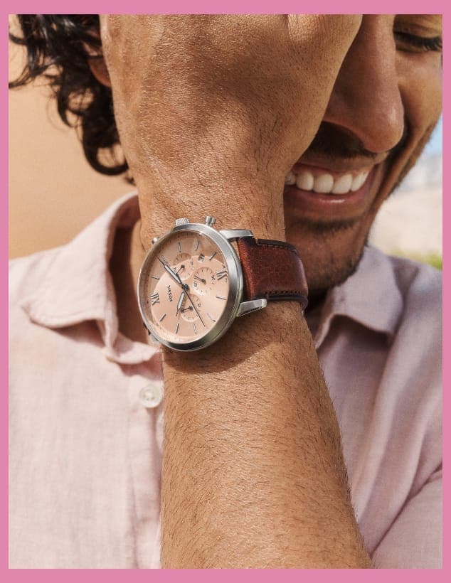 A man smiling and wearing a Neutra watch with a salmon-coloured dial.