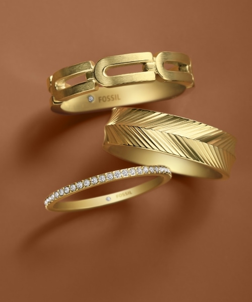 A stack of three gold-tone and crystal rings.