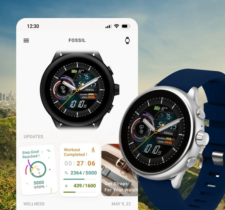 美しい景色を背景に、Fossilスマートウォッチアプリの機能を表示した調整済みスマートフォンスクリーン、その隣にブルーのシリコンストラップをあしらったGen 6 Wellness Editionスマートウォッチ。