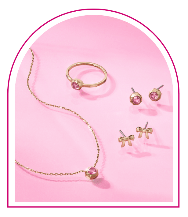 Ein pinker Hintergrund mit einem Fenster im Stil des Traumhauses von Barbie™. Im Fenster sieht man Styles aus unserer Limited Edition Barbie™ x Fossil Schmuckkollektion: eine goldfarbene Halskette mit passendem Ring und Ohrsteckern, alle mit stylishen pinken Glassteinverzierungen.