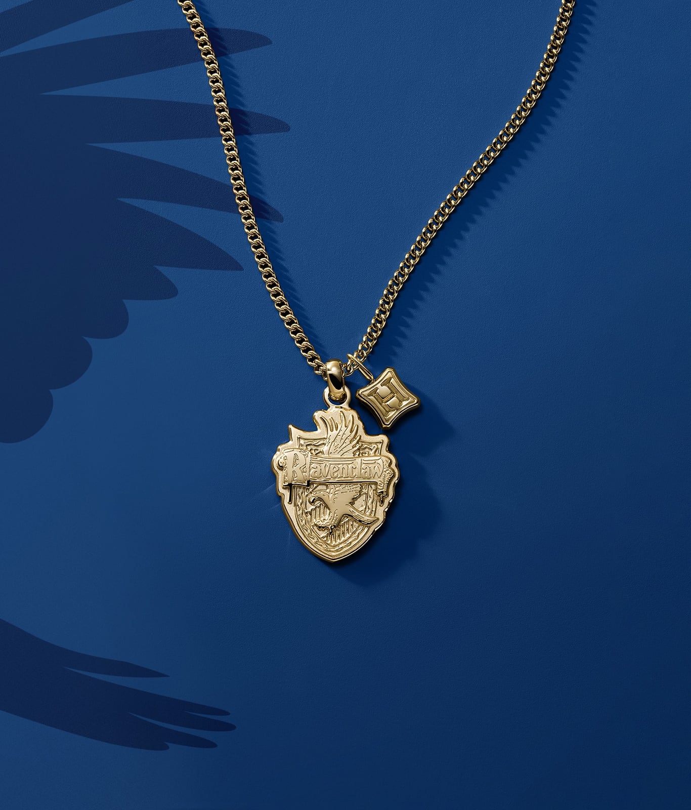 A gold-tone Ravenclaw house pendant.