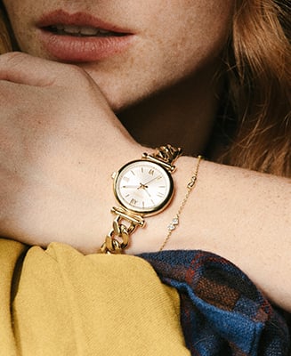 Ein Lifestyle-Bild von einer Frau mit verschränkten Armen, die eine Uhr Carlie und eine feines Armband trägt.
