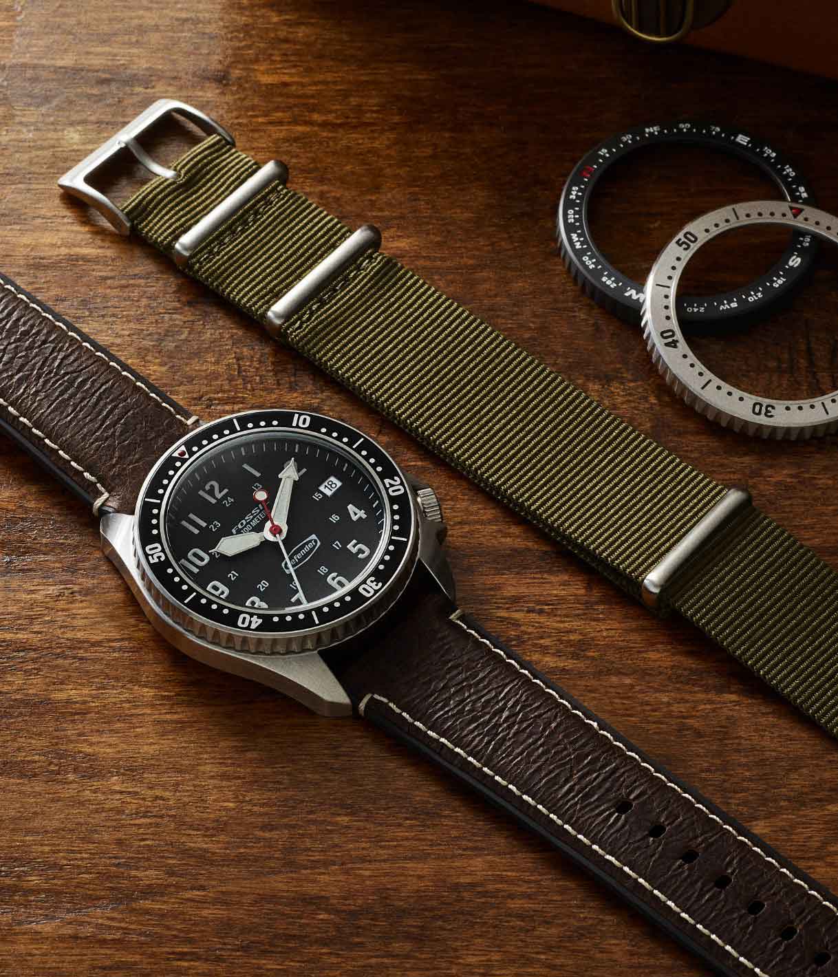 Defender watch beside extra strap and bezels.