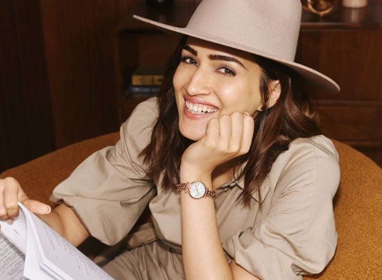 A woman wearing a hat and smiling while wearing a rose gold-tone Carlie watch.