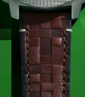 Un bracelet de montre en cuir brun marqué d’une texture en blocs.