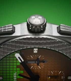 Une couronne de montre argentée ; dessus, le visage d’un Creeper de Minecraft gravé.