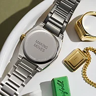 The caseback of a watch and necklace charm, waiting to be engraved.