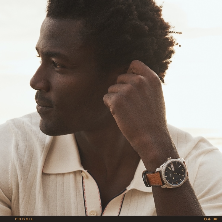 A man on the beach wearing a brown leather Machine watch.