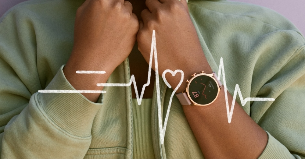 A woman wearing a Gen 6 smartwatch with heart rate tracking graphics.