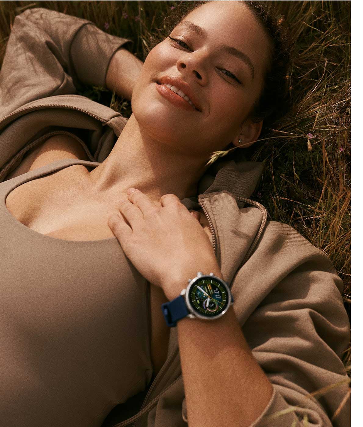 Une femme allongée portant une montre connectée hybride Gen 6 édition Wellness.