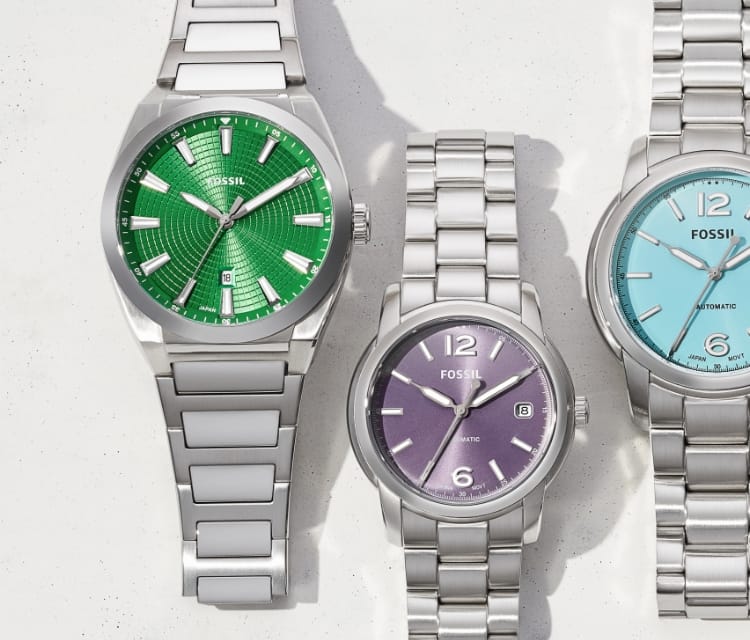 Five silver-tone watches with colored dials, including green, lavender, light blue, bright yellow and red.