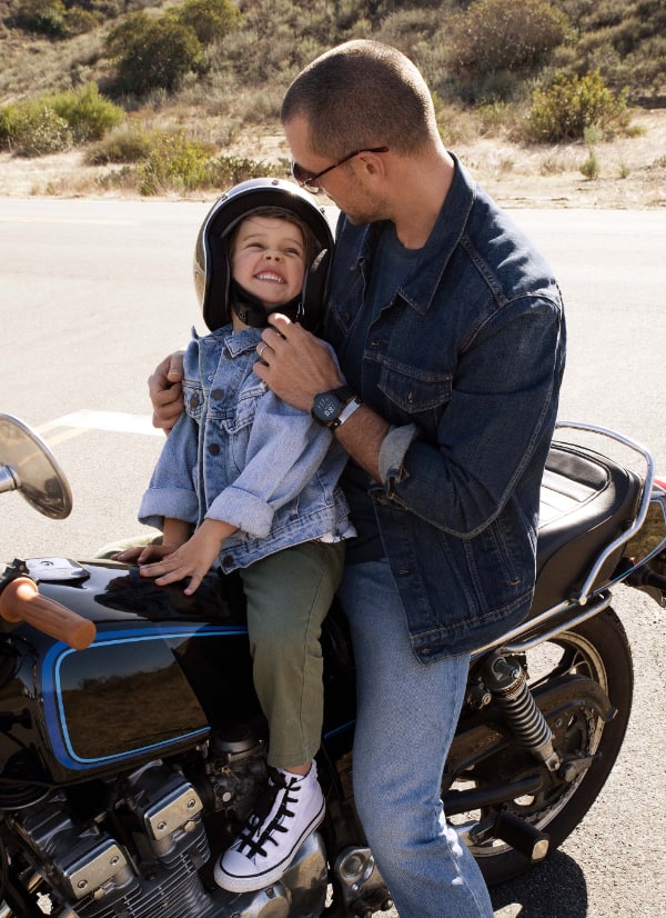 Un père et son fils sur une moto.