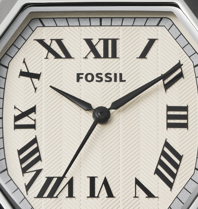 The linear-textured dial of the Fossil Harlow 33mm watch in a parchment color with black Roman numerals.