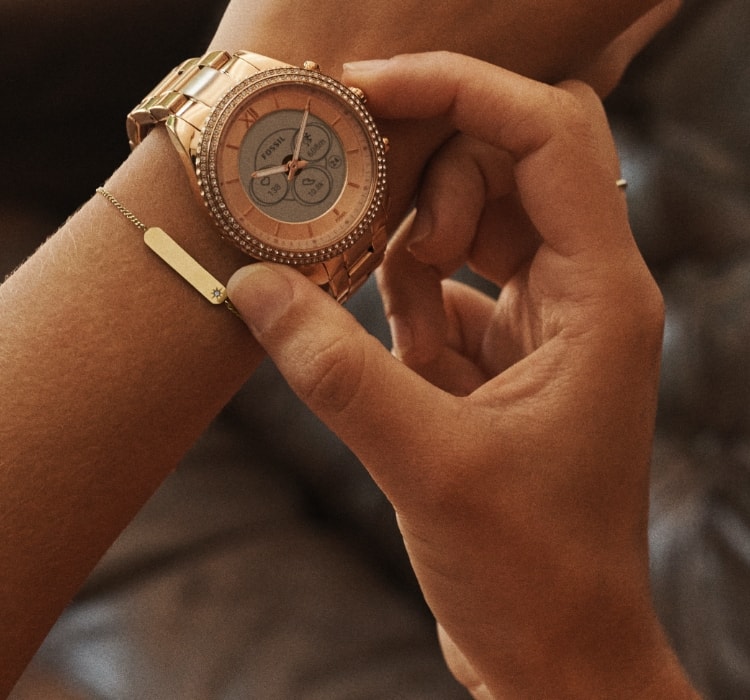 A closeup of a woman wearing a Gen 6 Hybrid smartwatch.