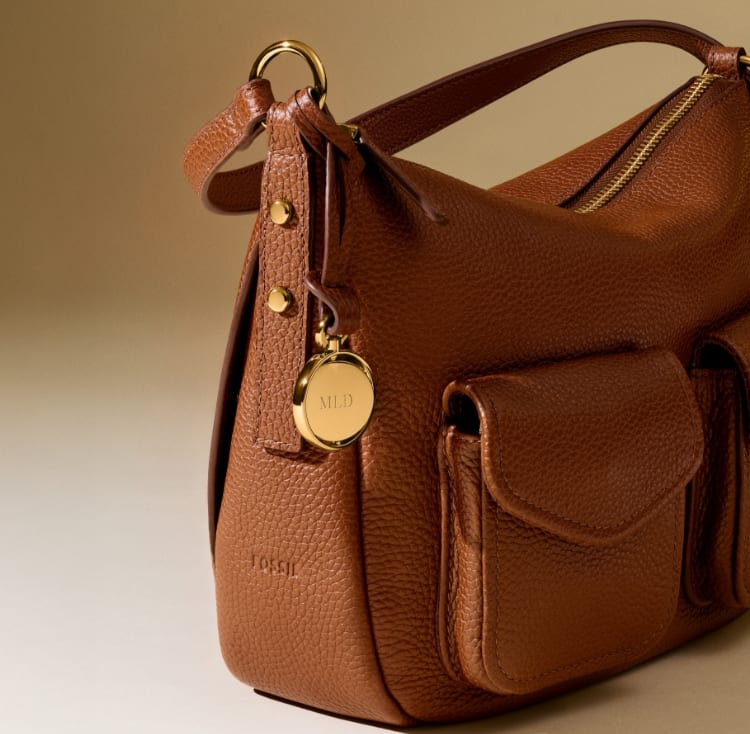 The brown leather Jessie Bucket Bag resting on a wicker chair.