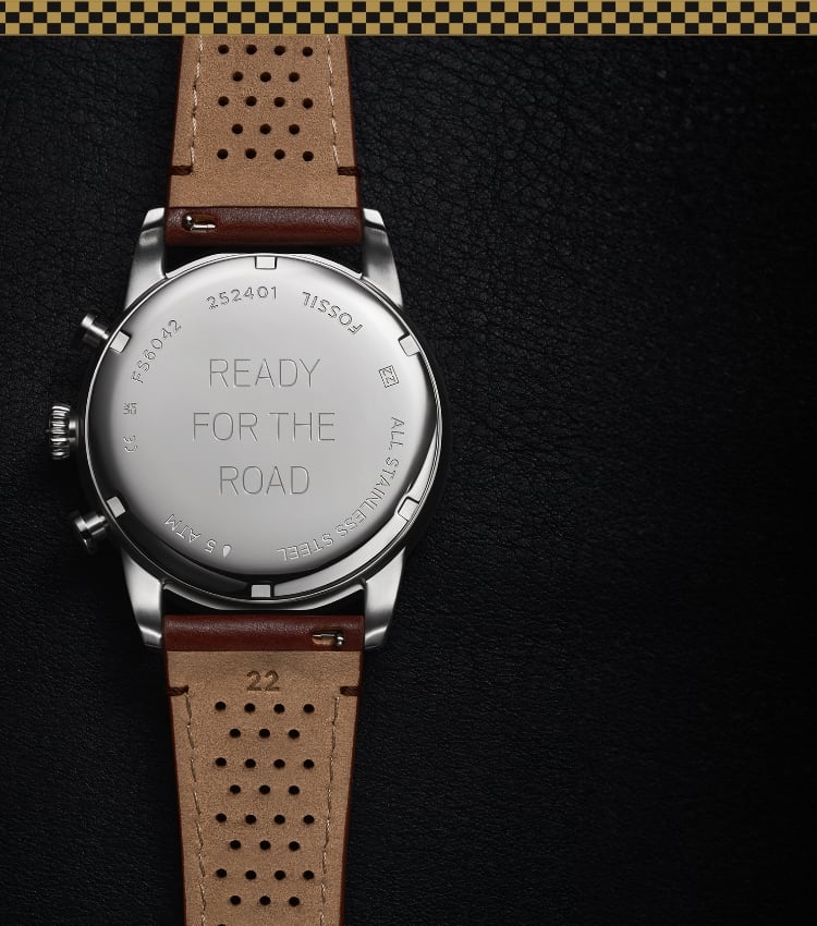 A mustard-and-black checkered border. The back of the brown leather Sport Tourer watch, engraved with Ready For The Road..