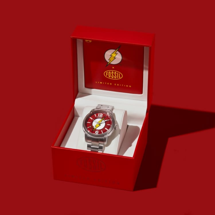 The Flash™ x Fossil watch packaging opening to reveal the limited-edition watch inside. 