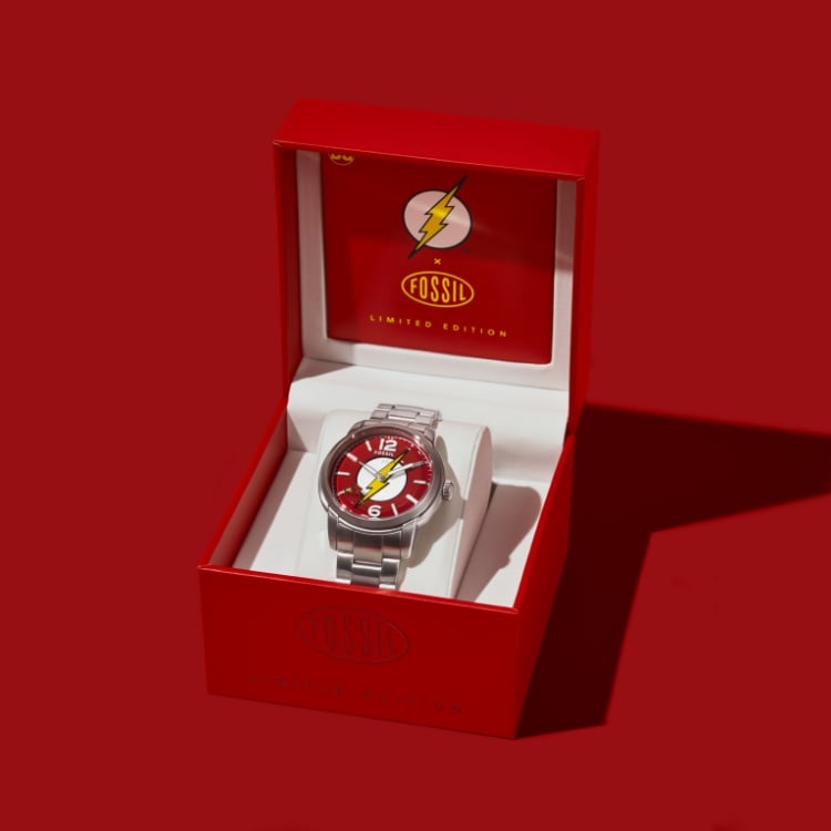 The Flash™ x Fossil watch packaging opening to reveal the limited edition watch inside.