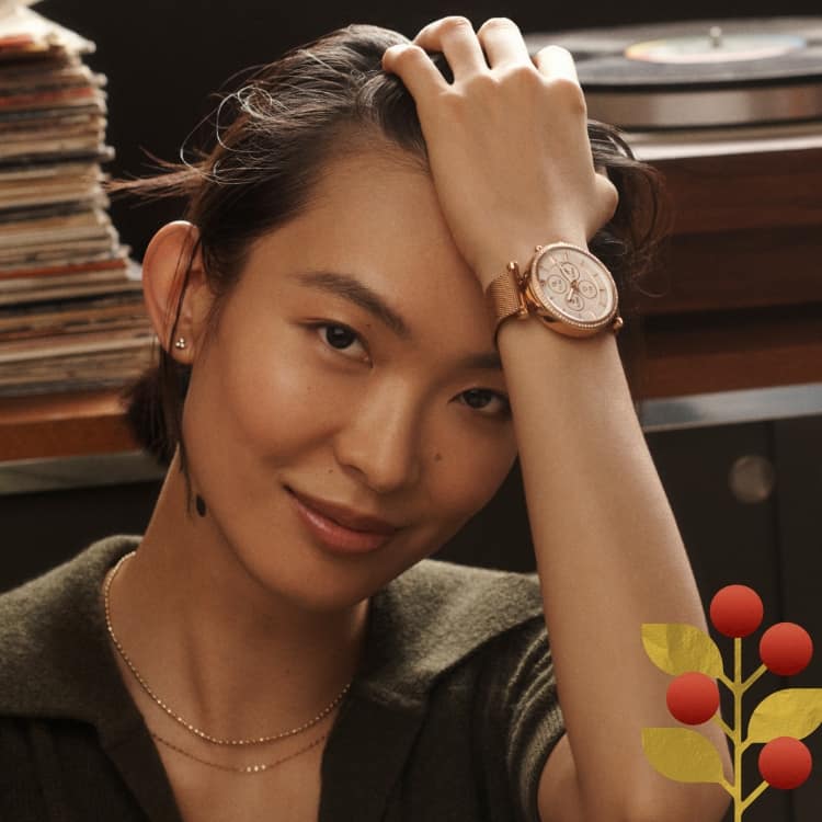 A woman wearing a rose gold-tone Gen 6 Hybrid smartwatch.