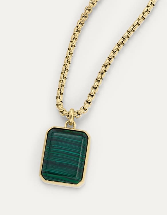 Gold necklace with an evergreen pendant.