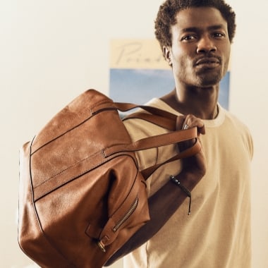 Un homme portant le polochon en cuir brun Raeford.