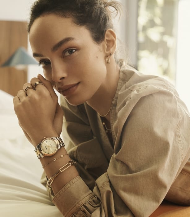 Woman wearing a two-tone Fossil Heritage watch with the Fossil Heritage D-Link jewelry collection.